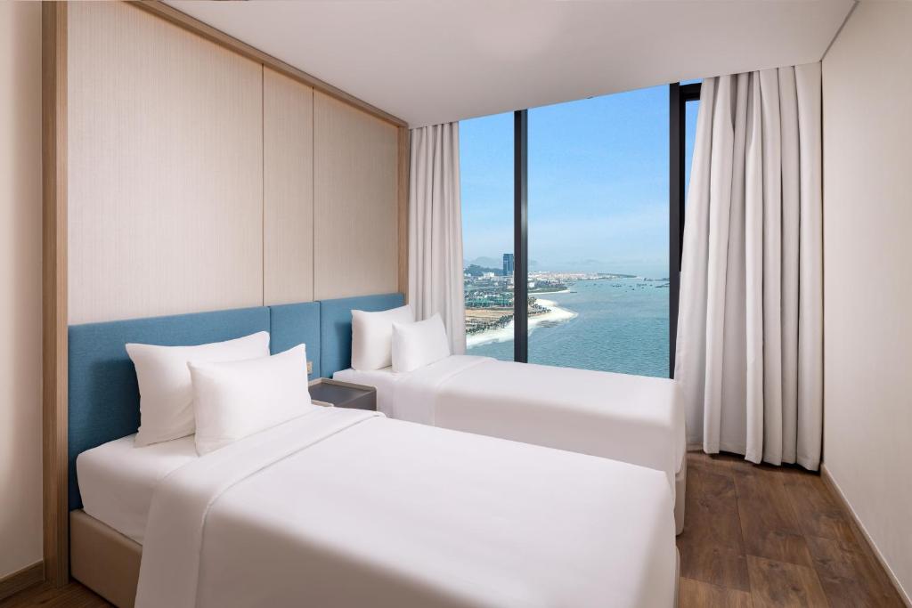 Giường trong phòng chung tại A La Carte Ha Long Bay Residence