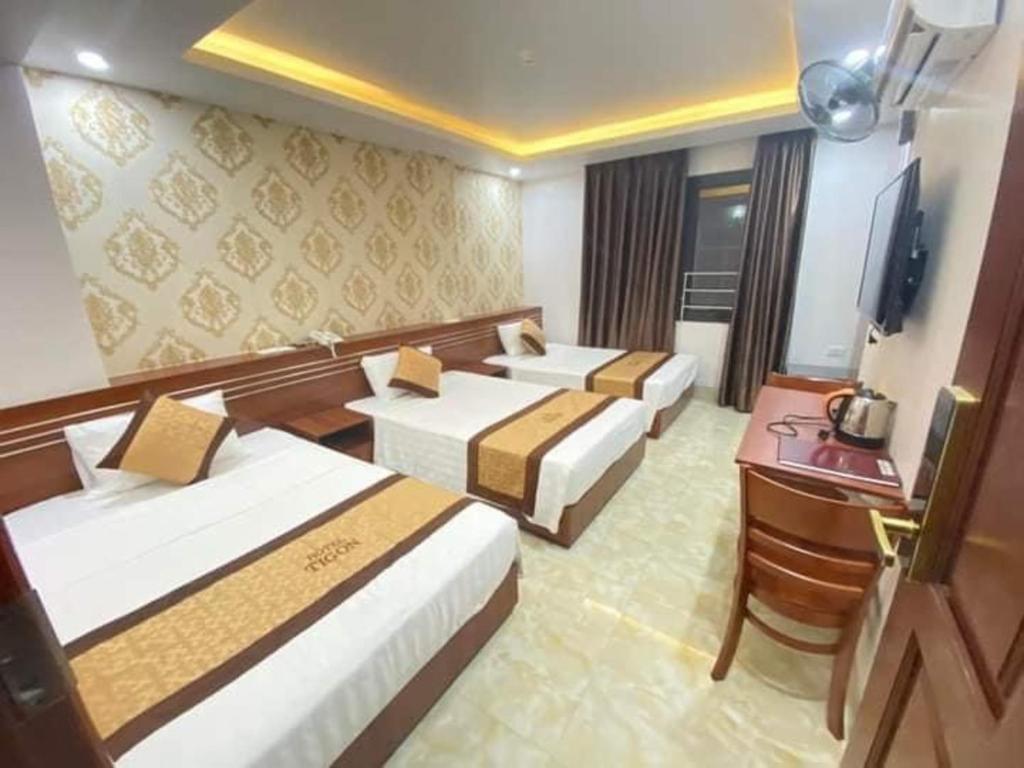 Giường trong phòng chung tại TiGon Hotel